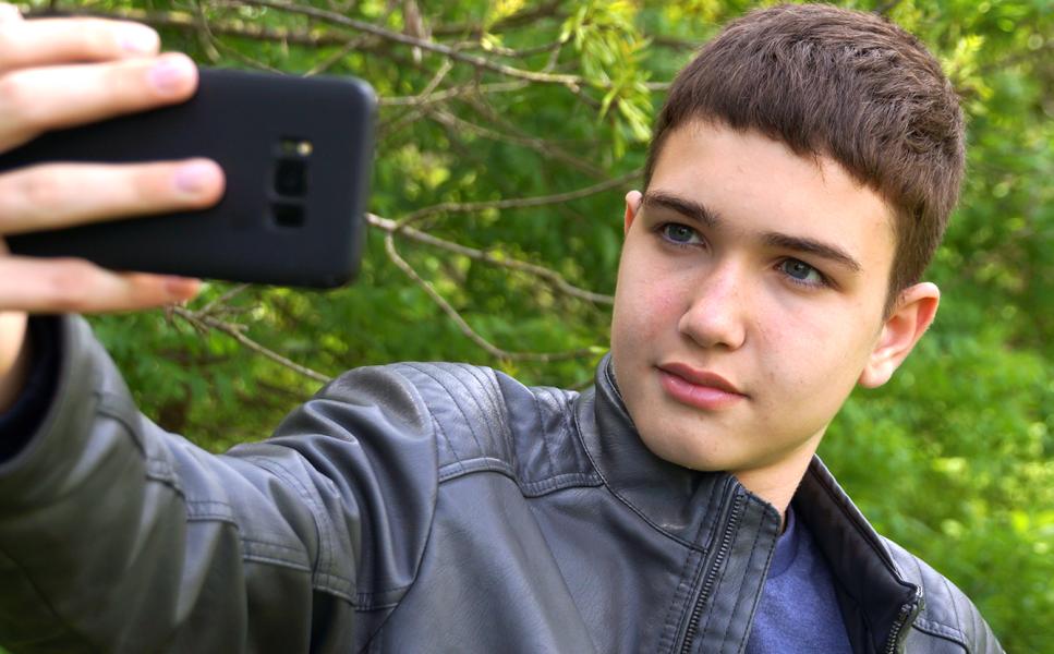 Ученик, който се снима с телефон.